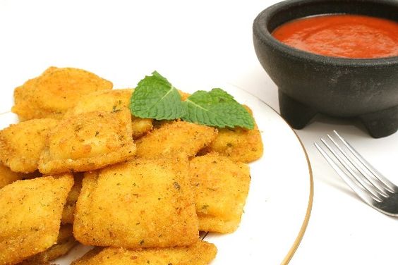 Quick and Easy Fried Ravioli on a white plate with a small black dish of marinara sauce next to it.