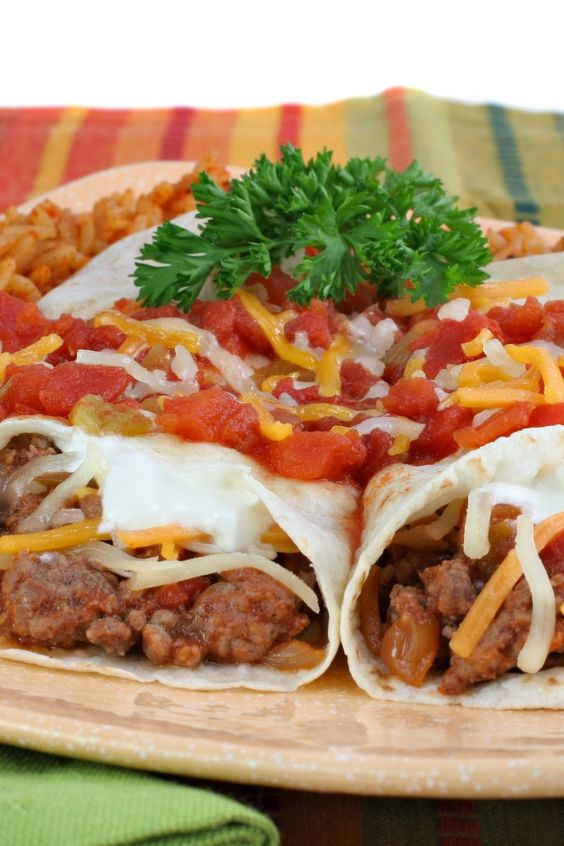 Closeup of Beef and Bean Burritos on a tan plate.