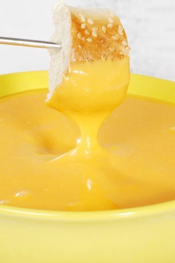 Closeup of Quick and Easy Beer and Cheddar Fondue in a yellow bowl.
