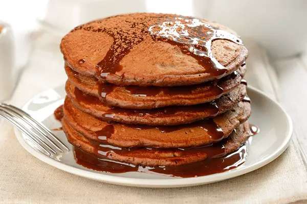A stack of Decadent Chocolate Pancakes on a white plate.