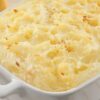 Closeup of Mashed Potatoes with Cream Cheese in a white casserole dish.