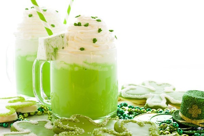 2 Copycat McDonald's Shamrock Shakes in clear glass mug, surrounded by St Patrick's Day decorations.