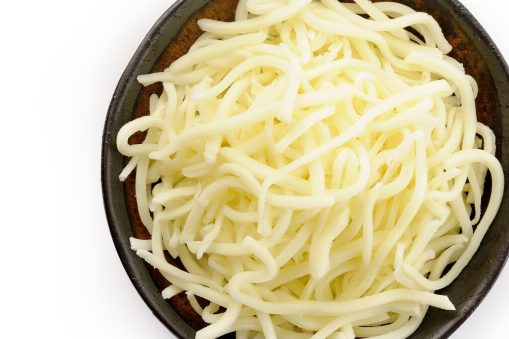 shredded mozzarella cheese in a brown bowl.
