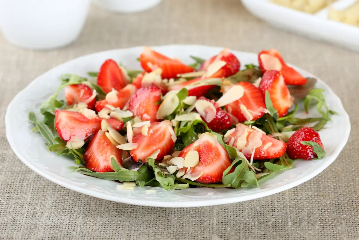 Balsamic Arugula Salad with Strawberries on a white plate.