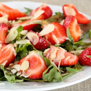 Balsamic Arugula Salad with Strawberries on a white plate.