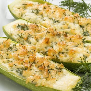 Closeup of Cheesy Stuffed Zucchini on a white plate.