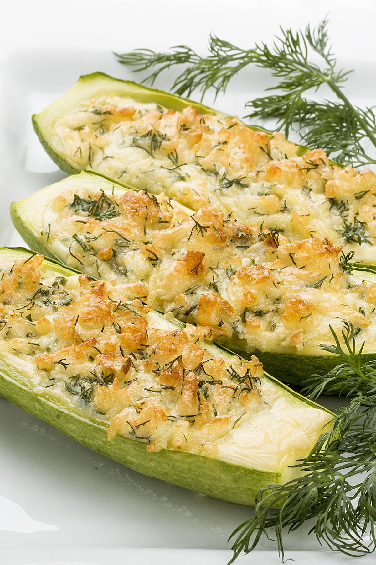 Closeup of Cheesy Stuffed Zucchini on a white plate.