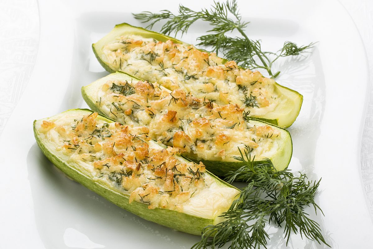 Cheese Stuffed Zucchini on a white plate with fresh dill.