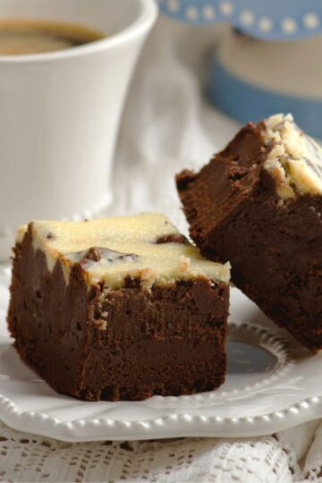 Closeup of 2 Luxurious Bailey's Irish Cream Infused Brownies on a white plate.