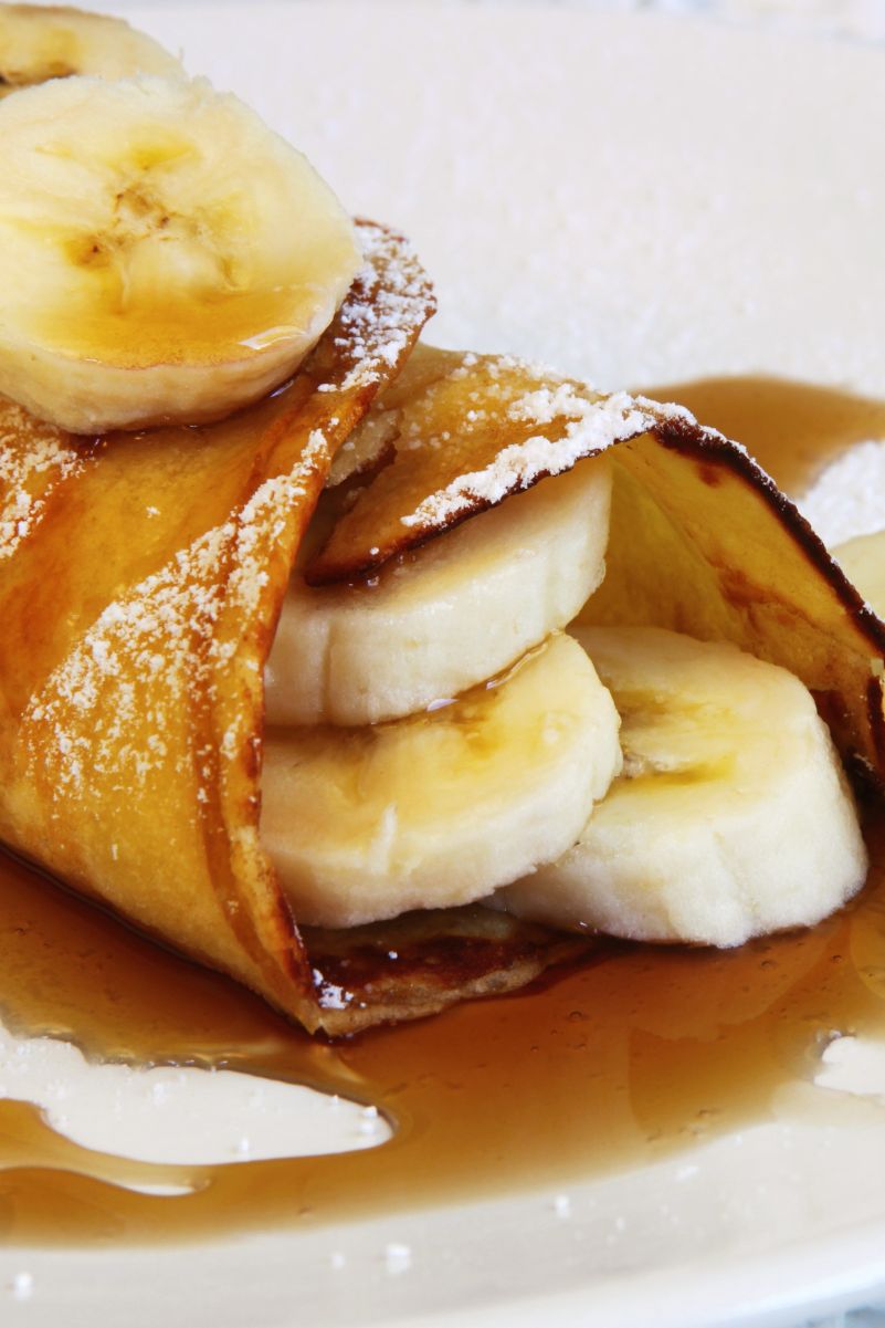 Closeup of Delectable Banana Stuffed Crepes on a white plate.