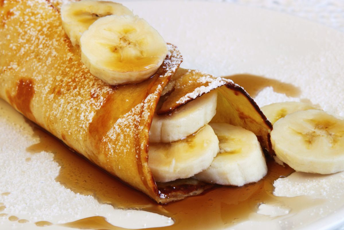 Delectable Banana Stuffed Crepes on a white plate.