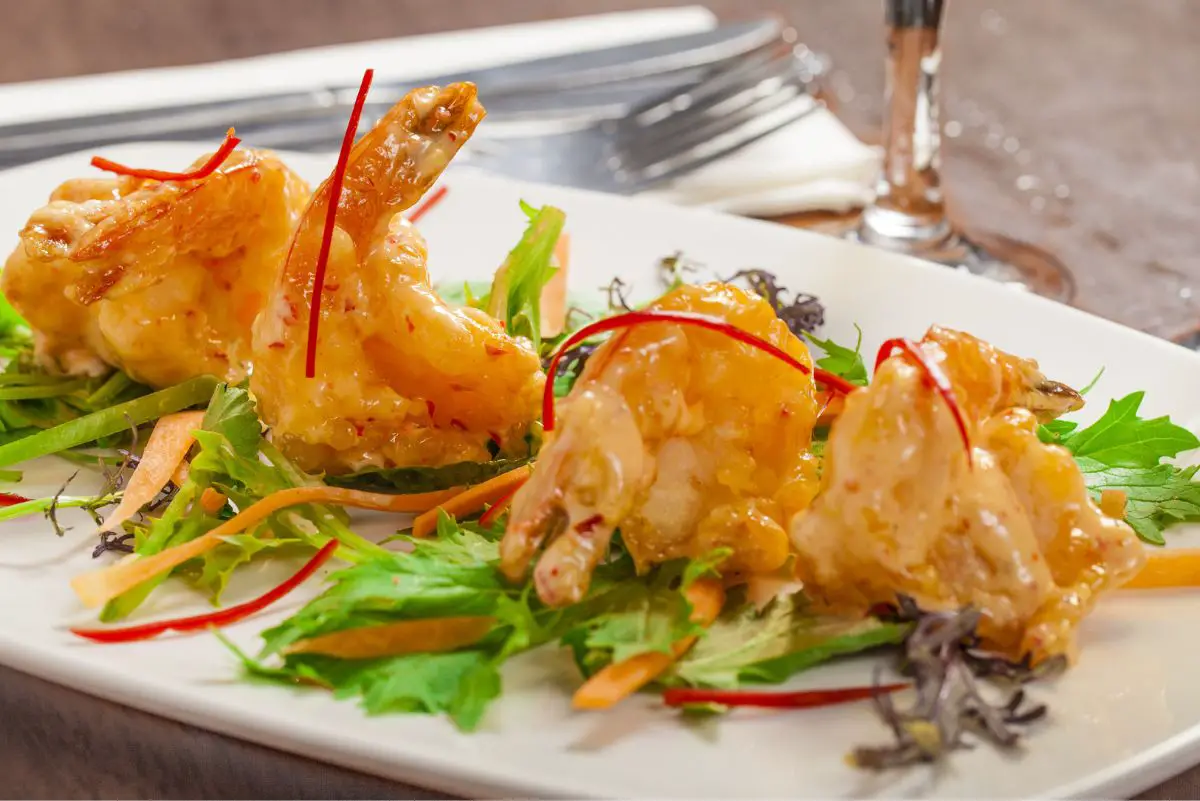 Delicious Copycat Bang Bang Shrimp (Bonefish Grill) on a white plate with lettuce.