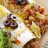 Closeup of Mouthwatering Homemade Beef Enchiladas on a white plate.