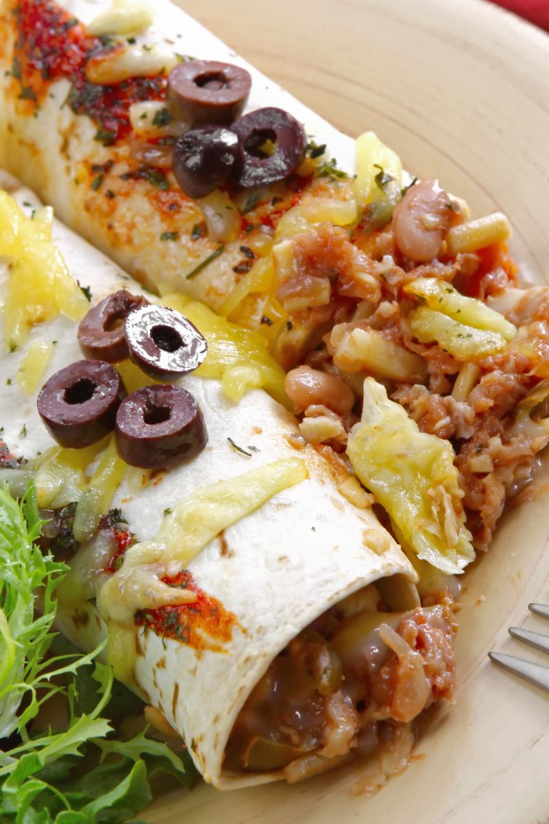 Closeup of Mouthwatering Homemade Beef Enchiladas on a white plate.