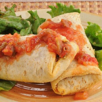 2 Beef and Bean chimichangas on a plate with lettuce.