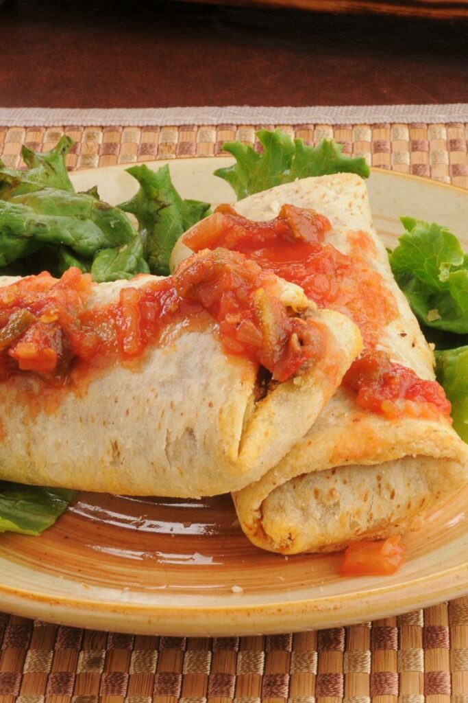 2 Beef and Bean chimichangas on a plate with lettuce.