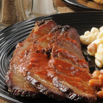 Closeup of Finger-Lickin' Slow Cooker BBQ Beef Brisket on a black plate.