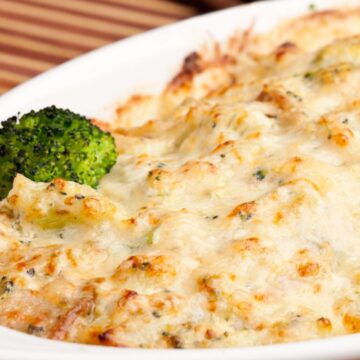 Closeup of Ultimate Broccoli Mushroom and Cheddar Casserole in a white baking dish.