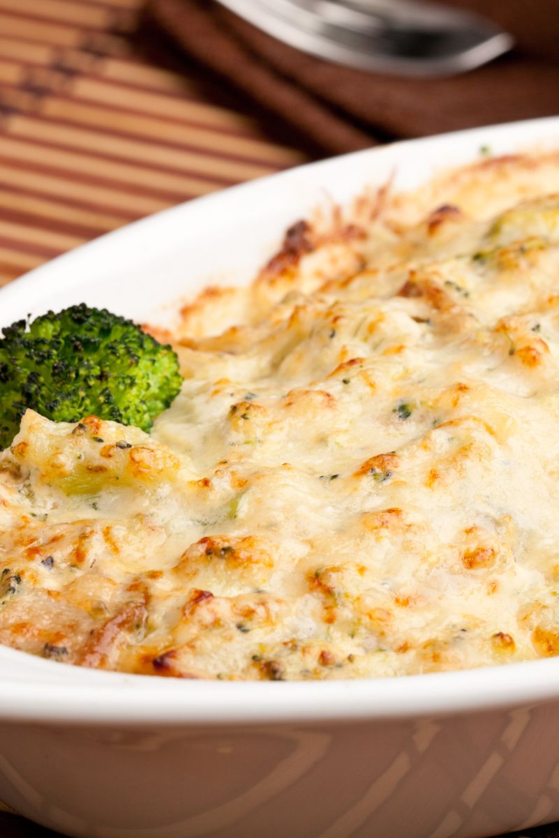 Closeup of Ultimate Broccoli Mushroom and Cheddar Casserole in a white baking dish.