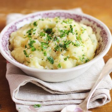 Cheesy Ranch Mashed Potatoes: in a white bowl sitting on top of a white cloth napkin.