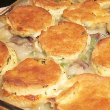 Chicken Stew with Biscuits (The Ultimate Comfort Food) in a clear glass baking dish.