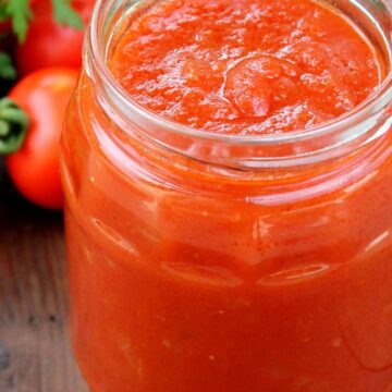 Closeup of Homemade Copycat Pizza Sauce (Pizza Hut) in a clear glass jar.