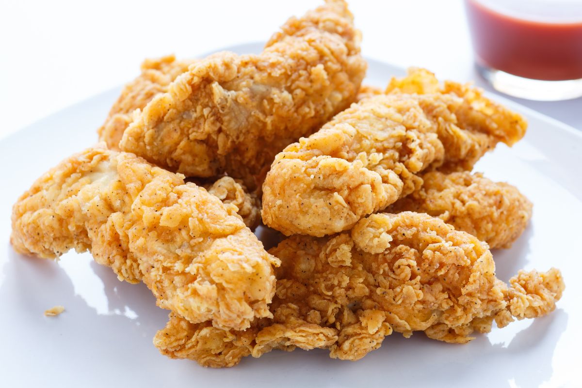 A pile of Chicken Fingers on a white plate.