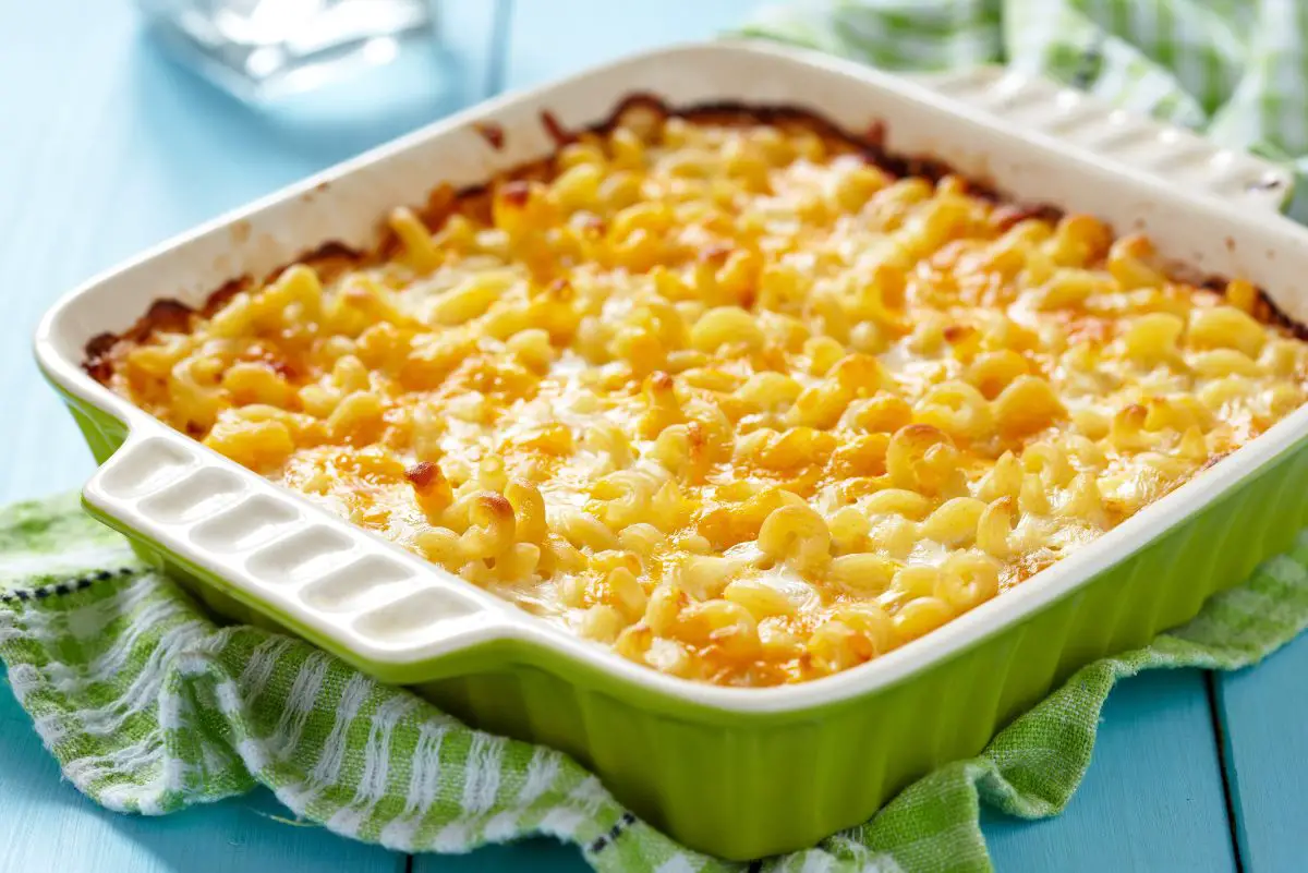 Best Baked Macaroni and Cheese in a green casserole dish sitting on a green and white dish towel.
