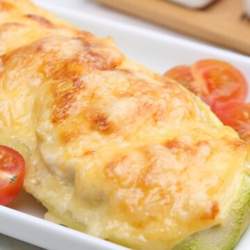 closeup of Grilled Garlic Parmesan Zucchini on a white plate.