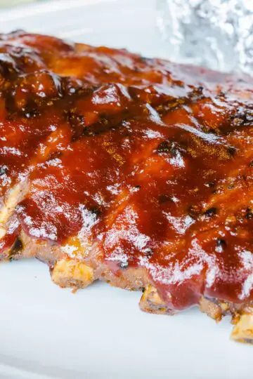 Closeup of Grilled Whisky Baby Back Ribs on a white background.