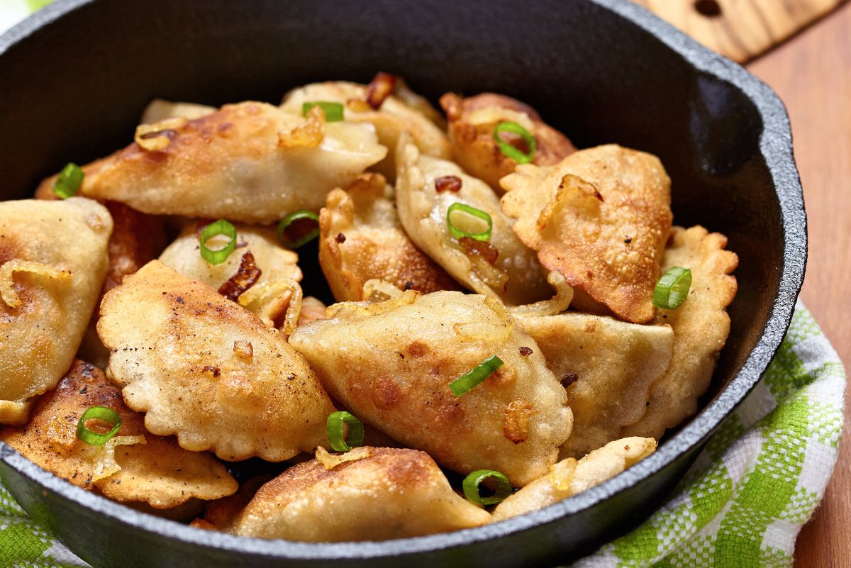 Closeup of Potato and Cheese Pierogis in a cast iron skillet.