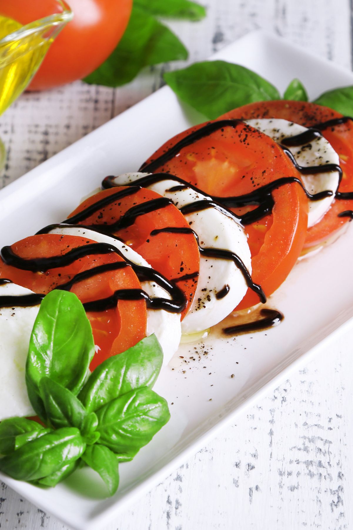 Closeup of Italian Balsamic Caprese Salad on a rectangular, white plate.