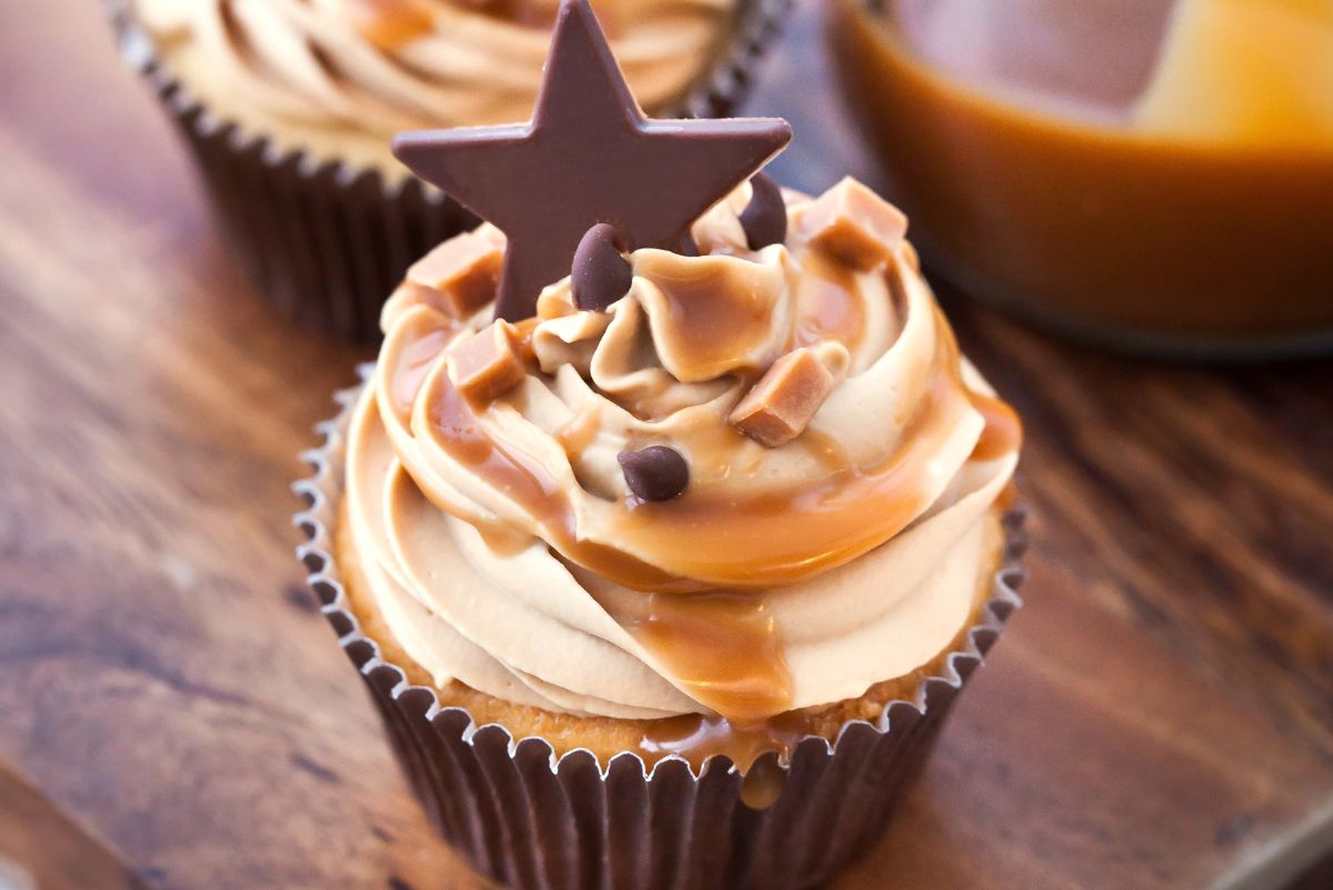 Closeup of Salted Caramel Almond Cupcake on a dark wooden surface.