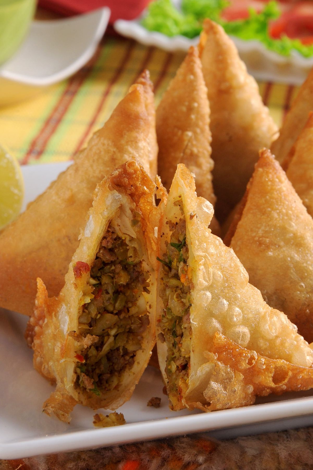 Closeup of Spicy Ground Beef Samosas on a square, white plate.