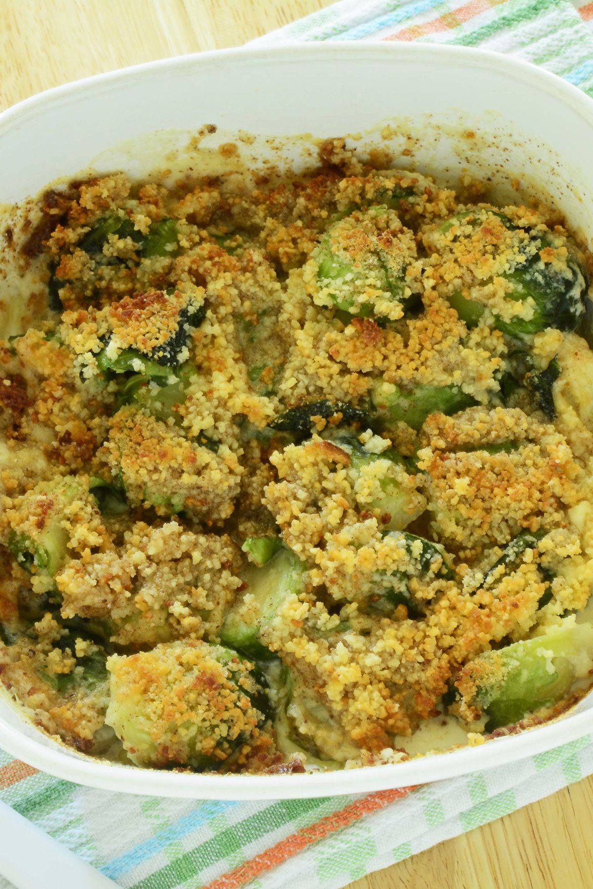 Closeup of Bacon Parmesan Brussels Sprout Gratin in a white casserole dish.