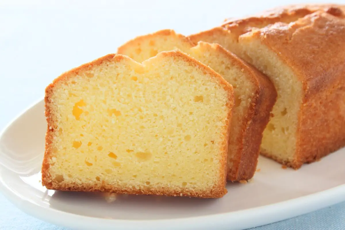 A half sliced Copycat Entenmann's Pound Cake on a white plate with a white background.