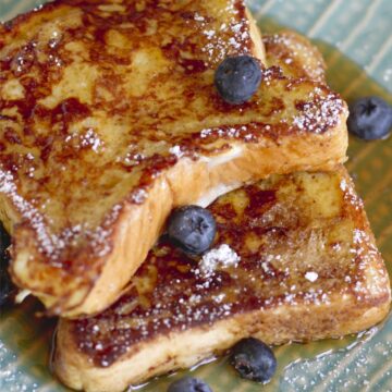 2 slices of Copycat Denny's French Toast Recipe on a patterned, light blue plate.