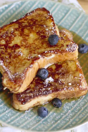 2 slices of Copycat Denny's French Toast Recipe on a patterned, light blue plate.