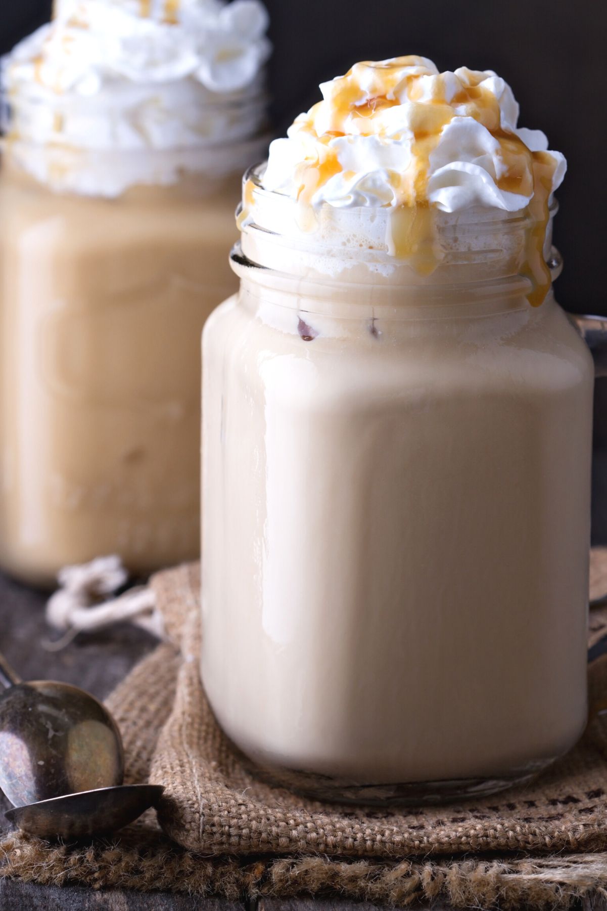 2 Copycat Starbucks Caramel Frappuccinos in mason jars.