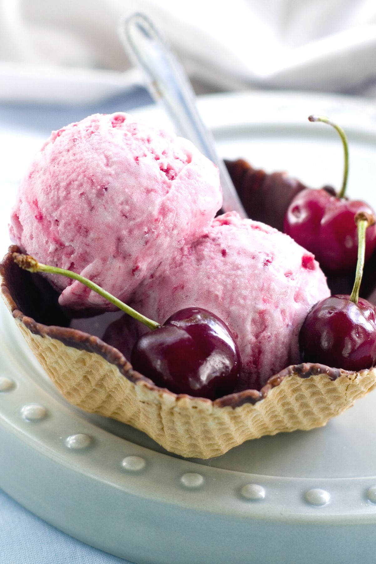 2 scoops of Homemade Cherry Ice Cream in a waffle bowl.