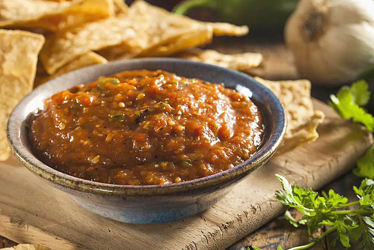 Quick and Easy Copycat Chili's Salsa in a gray bowl, surrounded by tortilla chips.