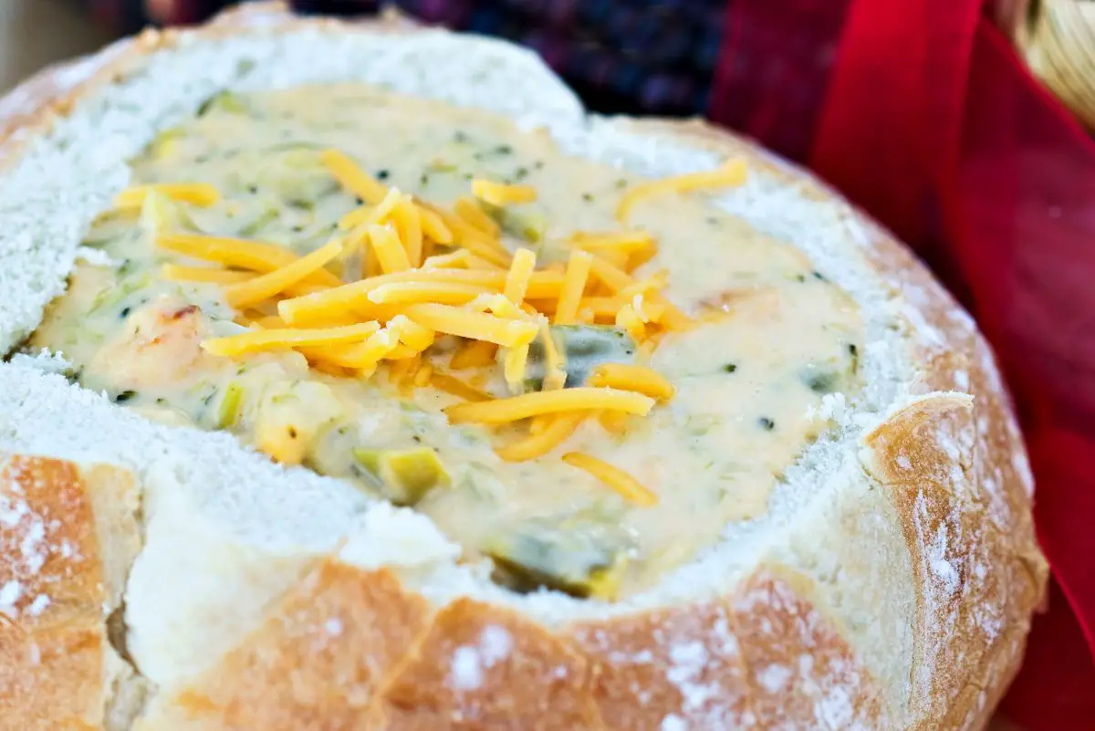 Broccoli Cheddar Soup (Panera Copycat) in a bread bowl with a red napkin in the background.