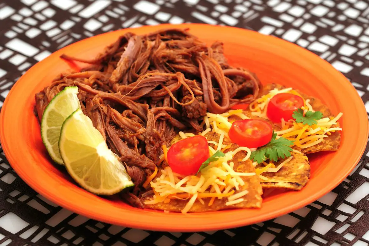 Slow Cooker Barbacoa Beef (Chipotle Copycat) on an orange plate.